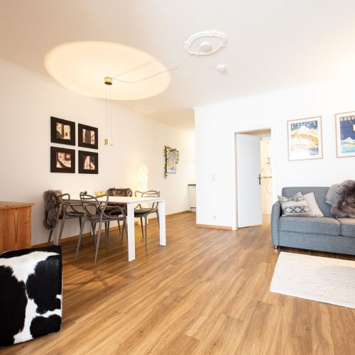 Heller Wohnbereich mit Sofa und Esstisch in Ferienwohnung in Garmisch-Patenkirchen