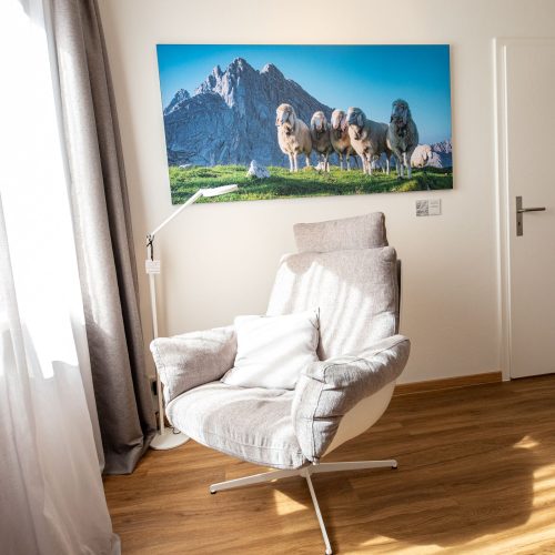 Sessel unter Bild von Schafen in Ferienwohnung in Garmisch-Patenkirchen