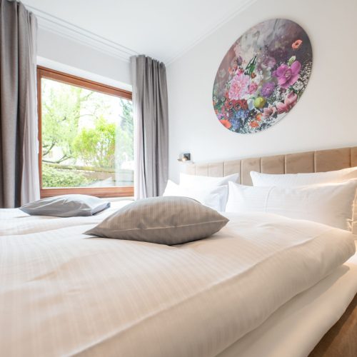 Bett mit rundem Blumenbild in Ferienwohnung in Garmisch-Partenkirchen