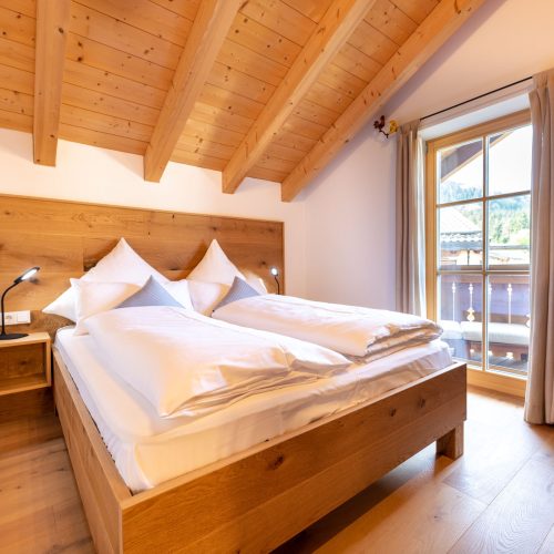 Weiches Bett mit Holzgestell in Ferienwohnung in Garmisch-Partenkirchen