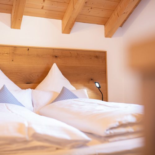 Weiches Bett mit Holzrückwand in Ferienwohnung in Garmisch-Partenkirchen