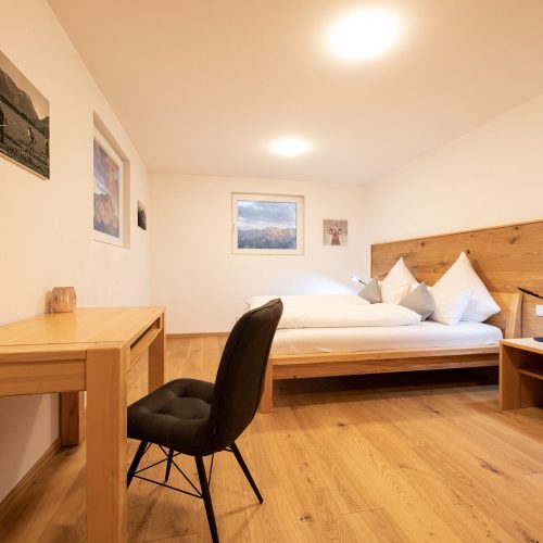 Schlafzimmer im Holzdesign mit hellen Lampen in Ferienwohnung in Garmisch-Partenkirchen