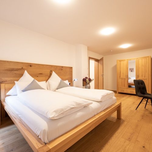 Doppelbett im Schlafzimmer in Holzoptik in Ferienwohnung in Garmisch-Partenkirchen