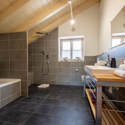 Großes Badezimmer mit dunklen Fliesen in Ferienwohnung in Garmisch-Partenkirchen