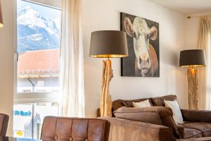 Sofa zwischen Lampen mit Holzstamm in Ferienwohnung in Garmisch-Patenkirchen