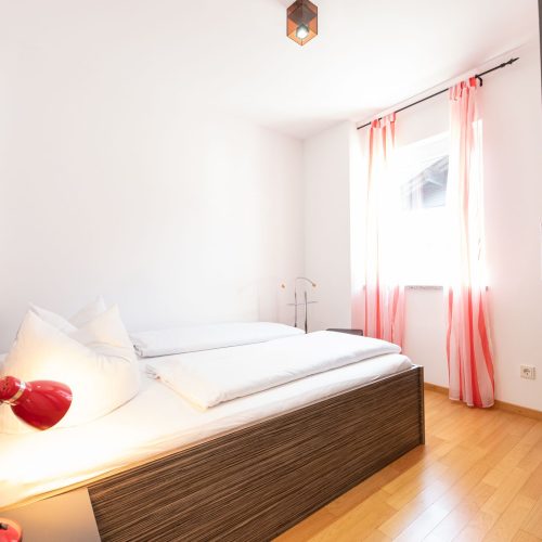 Kleines Schlafzimmer mit Bett mit Holzrahmen in Ferienwohnung in Garmisch-Patenkirchen