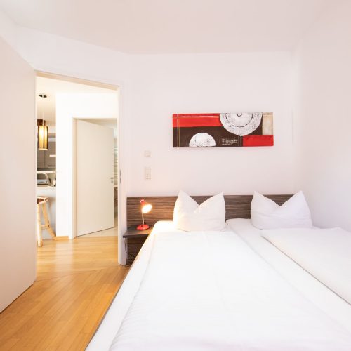 Doppelbett mit schmalem Bild in Ferienwohnung in Garmisch-Patenkirchen