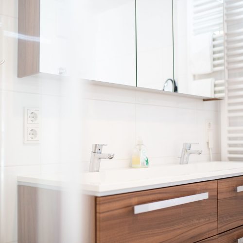 Waschbecken mit zwei Wasserhähnen und Seife in Ferienwohnung in Garmisch-Patenkirchen