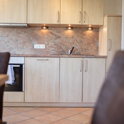 Küchenzeile mit Wandfliesen und Holzschränken in Ferienwohnung in Garmisch-Patenkirchen
