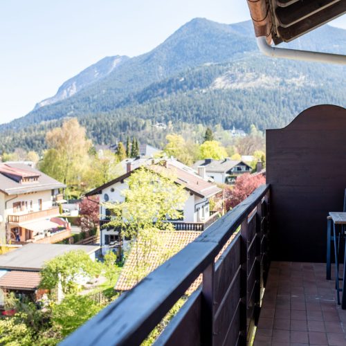 Balkon mit kleinem Tisch und zwei Stühlen in Ferienwohnung in Garmisch-Patenkirchen