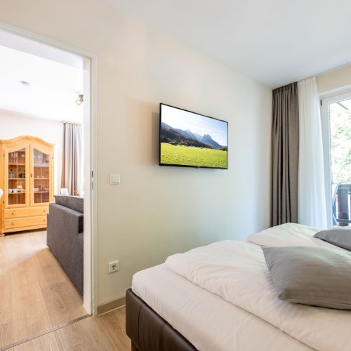 Doppelbett mit Fernseher in Ferienwohnung in Garmisch-Partenkirchen