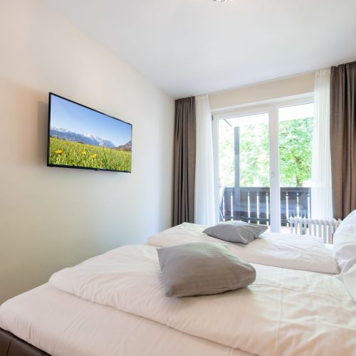 Doppelbett mit Fernseher in Ferienwohnung in Garmisch-Partenkirchen