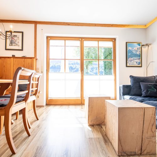 Wohnzimmer mit zwei kleinen Holztischen in Ferienwohnung in Garmisch-Partenkirchen