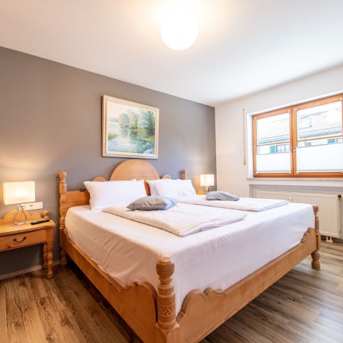 Schlafzimmer mit einem Holz Bett in Ferienwohnung in Garmisch-Partenkirchen